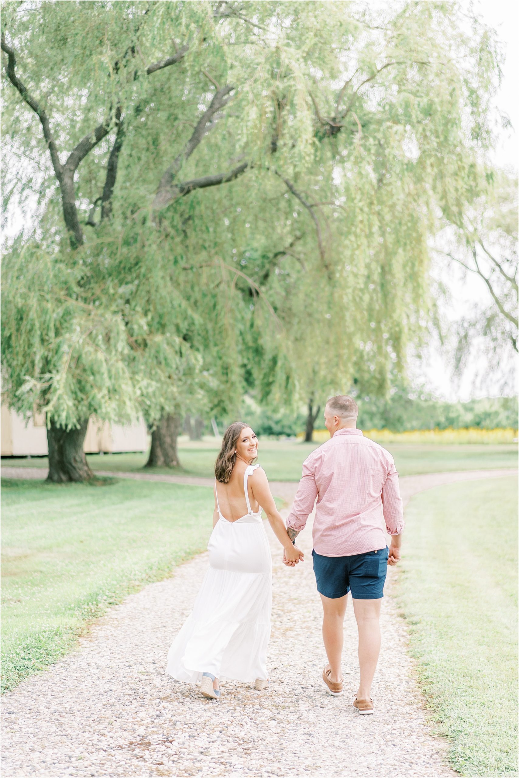 Couple engagement photos at Salt Air Farm holding hands and walking